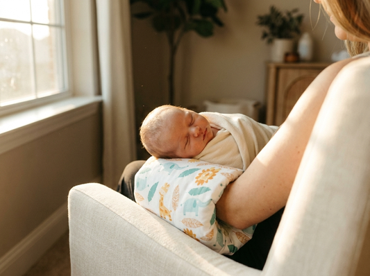 Parent feeding a newborn using the Tinyyytales arm pillow